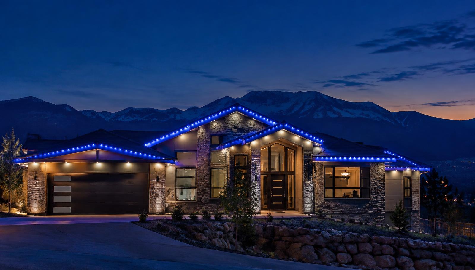 Colorado home with permanent blue LED roofline lighting at dusk
